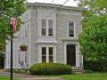 This house is an original Italianate style building with the classic features of a low pitched roof, ornamental brackets under the eaves and monumental (2 story) protruding bay windows with fully developed ornamental trim.